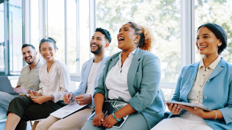 Group of professionals laughing during a meeting | Changing the Future of Psychiatry Together | Mindful Health Solutions