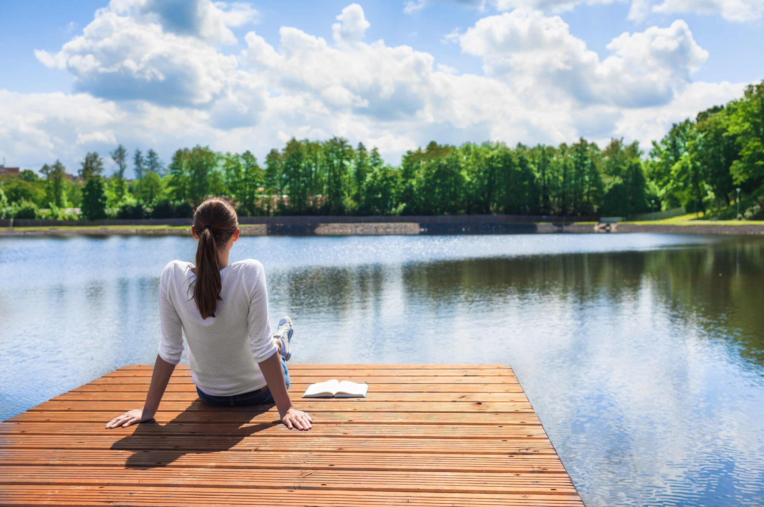 Woman peacefully sitting on dock in preparation for IV ketamine therapy
